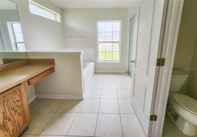 bathroom with a washtub, tile patterned flooring, and toilet