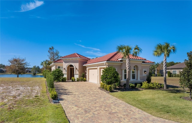 mediterranean / spanish home with a garage, a water view, and a front yard