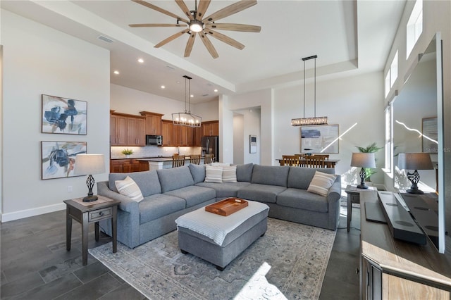 living room with ceiling fan with notable chandelier