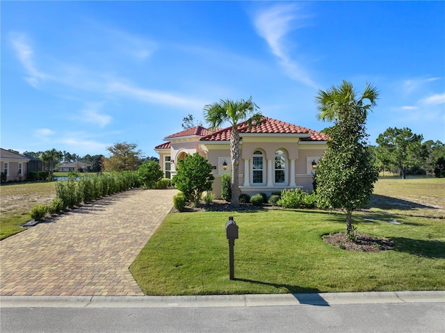 mediterranean / spanish-style home with a front lawn