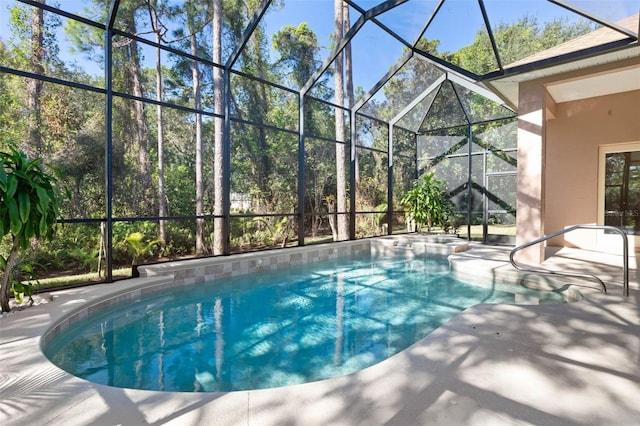 view of pool featuring glass enclosure and a patio area