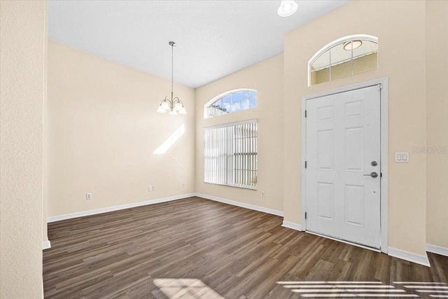 foyer entrance featuring an inviting chandelier and dark hardwood / wood-style floors