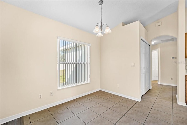 unfurnished room featuring light tile patterned floors and a chandelier