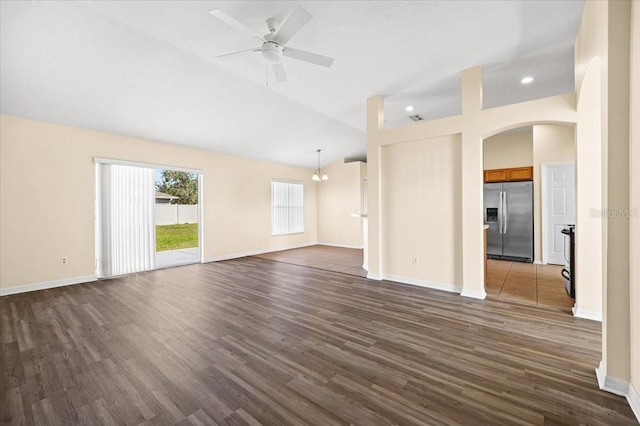 unfurnished living room featuring lofted ceiling, ceiling fan with notable chandelier, and dark wood-type flooring