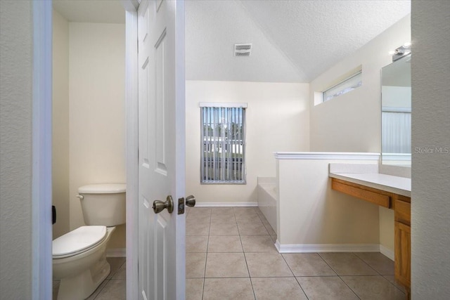 bathroom featuring a tub to relax in, toilet, tile patterned flooring, and vanity