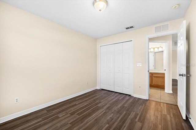 unfurnished bedroom featuring dark wood-type flooring and a closet