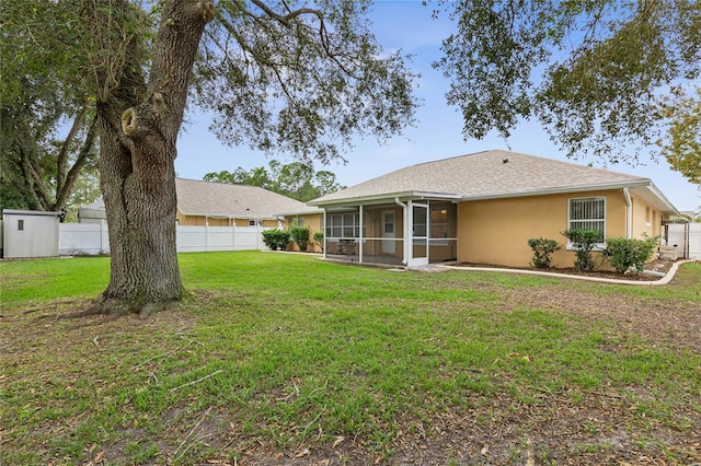 back of property with a lawn and a sunroom