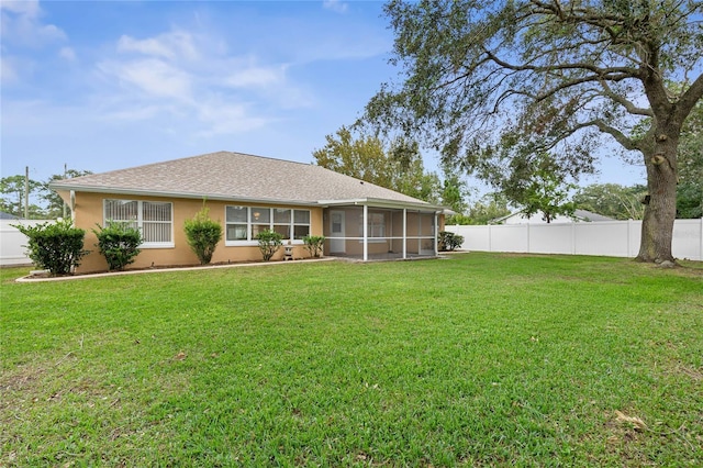 back of house with a sunroom and a yard