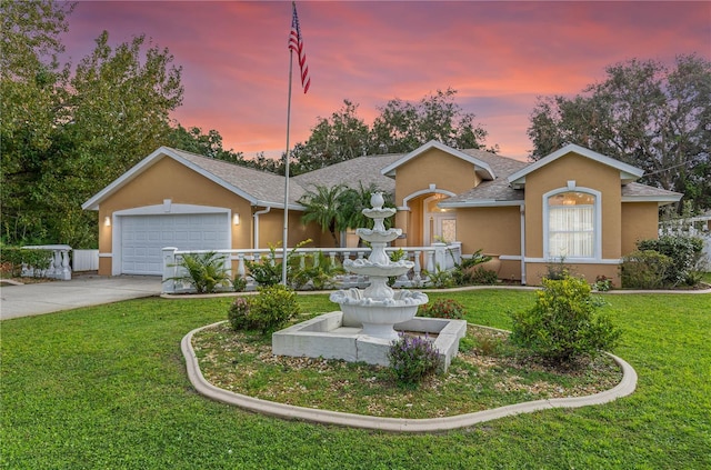 ranch-style home featuring a lawn and a garage