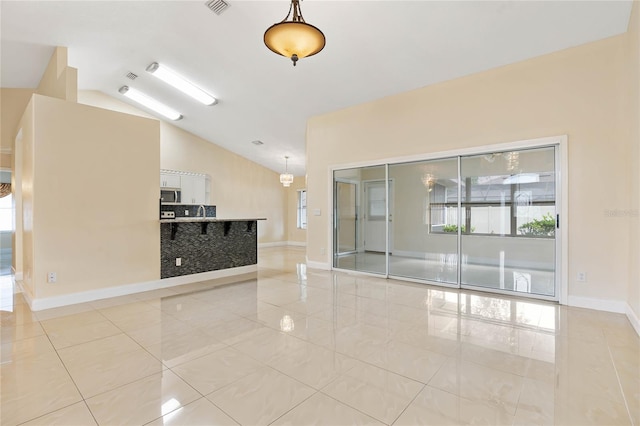 empty room with light tile patterned flooring and lofted ceiling