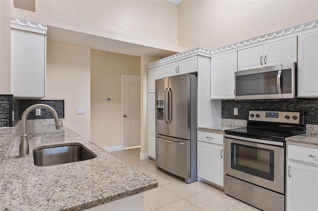 kitchen featuring light stone counters, white cabinetry, sink, and appliances with stainless steel finishes