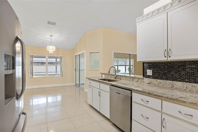 kitchen with sink, tasteful backsplash, decorative light fixtures, white cabinets, and appliances with stainless steel finishes