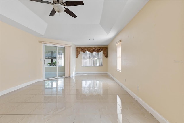 tiled empty room featuring ceiling fan and plenty of natural light