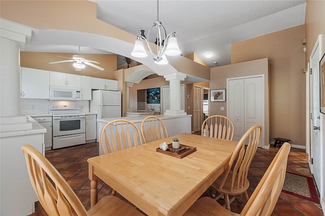 dining space featuring decorative columns, ceiling fan with notable chandelier, and vaulted ceiling