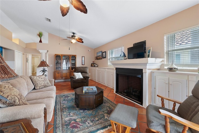 tiled living room with vaulted ceiling, ceiling fan, and a healthy amount of sunlight