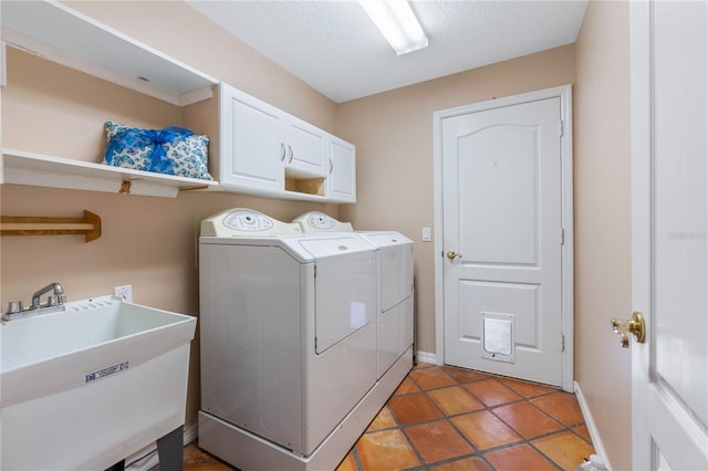 laundry area featuring cabinets, a textured ceiling, separate washer and dryer, and sink