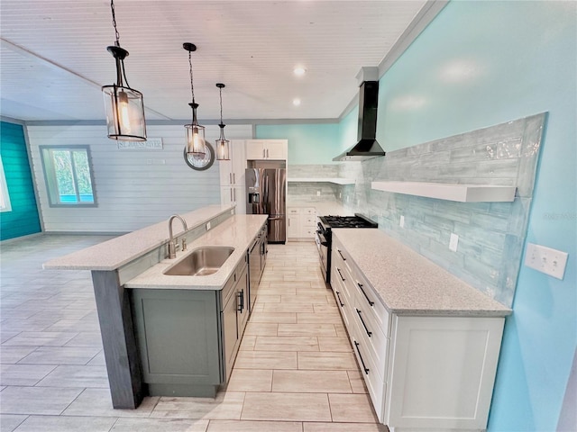 kitchen featuring stainless steel appliances, sink, wall chimney range hood, decorative light fixtures, and white cabinets