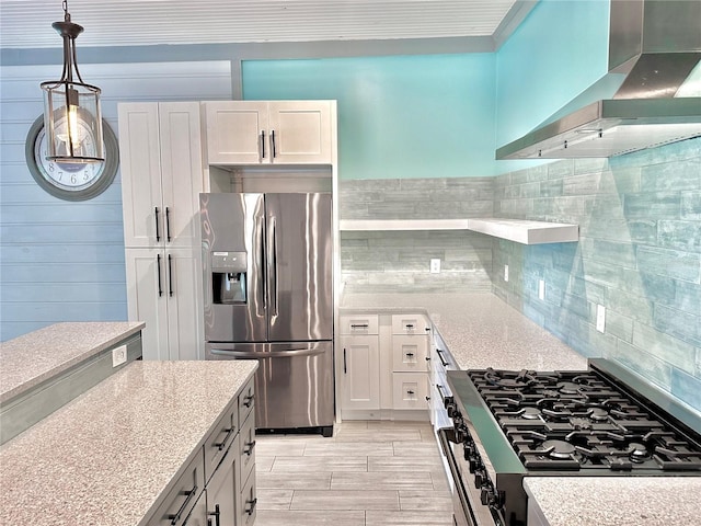 kitchen featuring decorative backsplash, stainless steel appliances, white cabinetry, and wall chimney exhaust hood