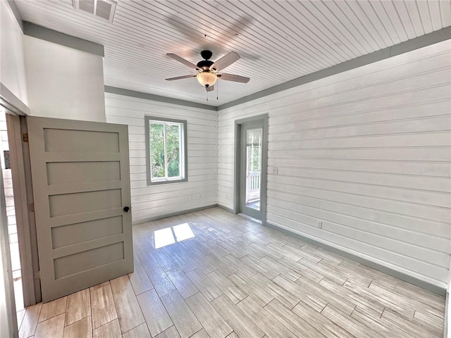 unfurnished room featuring light hardwood / wood-style flooring, ceiling fan, wooden walls, and wood ceiling