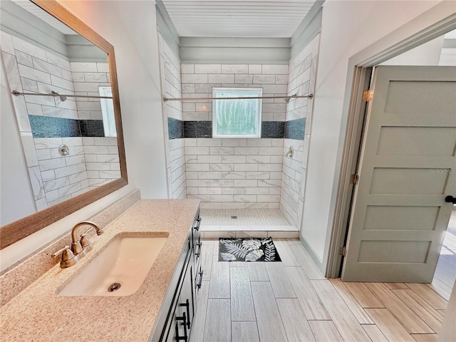 bathroom with vanity and a tile shower