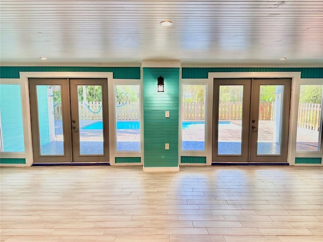 entryway featuring a wealth of natural light, french doors, and light wood-type flooring