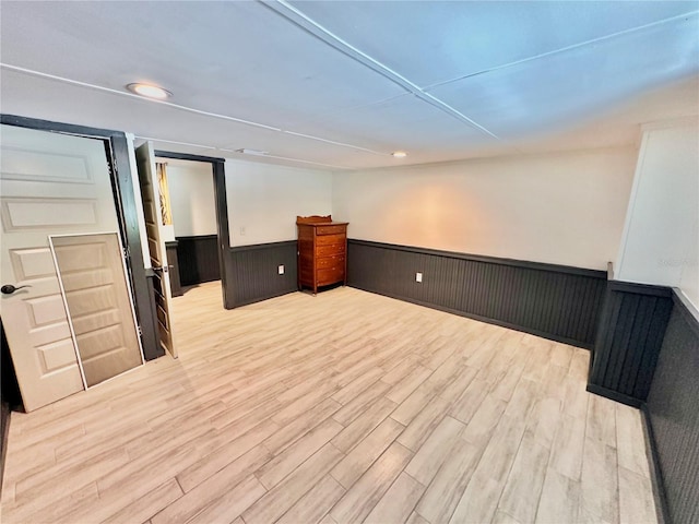 interior space with wood walls and light hardwood / wood-style floors