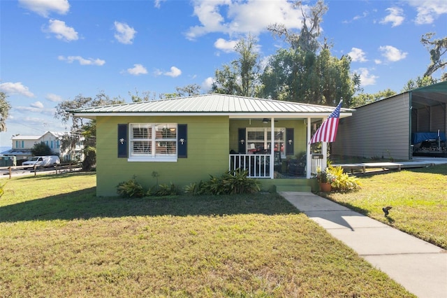 bungalow with covered porch, a carport, and a front lawn