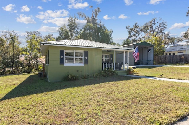 bungalow featuring a carport, covered porch, and a front lawn