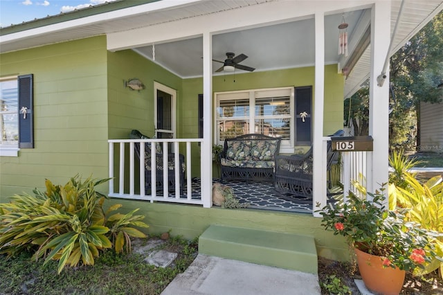 view of exterior entry with a porch and ceiling fan