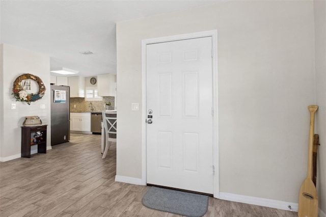 entryway featuring sink and light hardwood / wood-style flooring