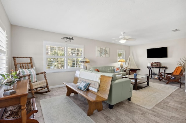 living room featuring ceiling fan, a wealth of natural light, and light hardwood / wood-style flooring