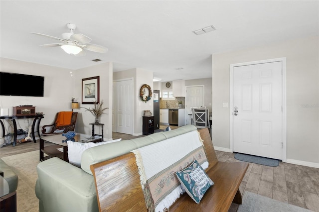 living room with ceiling fan and light wood-type flooring