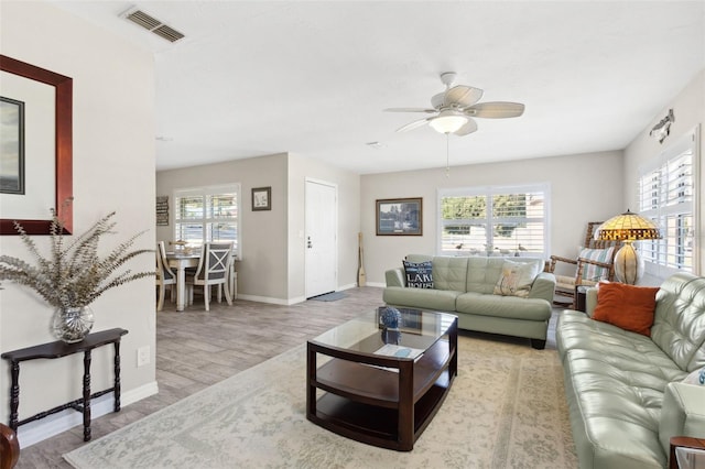 living room featuring light wood-type flooring, a wealth of natural light, and ceiling fan