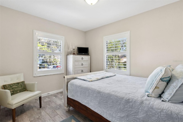 bedroom featuring wood-type flooring and multiple windows