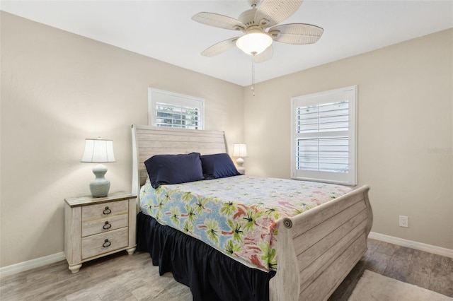 bedroom with multiple windows, ceiling fan, and light wood-type flooring