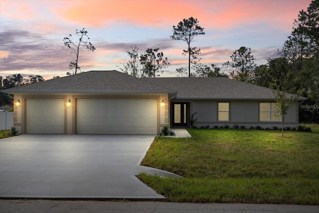 view of front of house with a yard and a garage