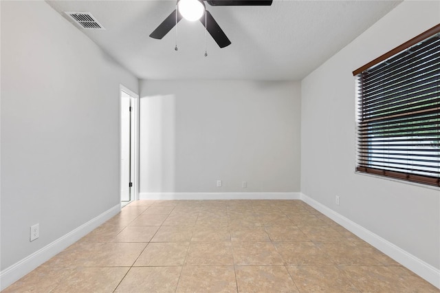 tiled empty room with a textured ceiling and ceiling fan