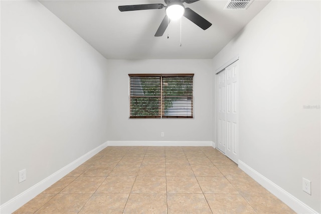 tiled empty room featuring ceiling fan