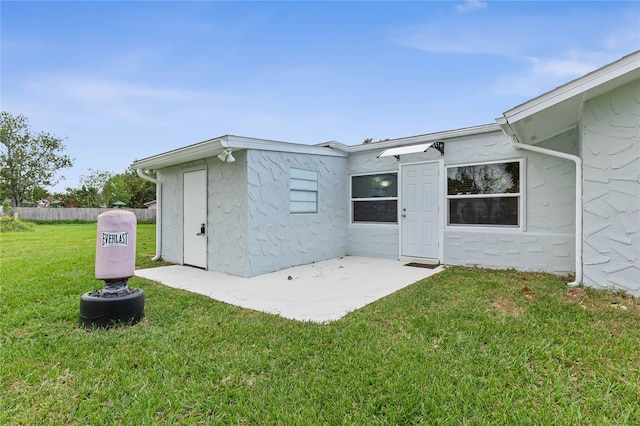 rear view of property featuring a lawn