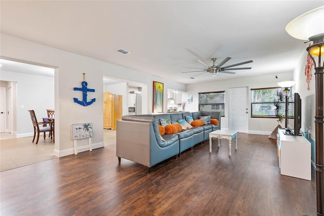 living room featuring ceiling fan and dark wood-type flooring