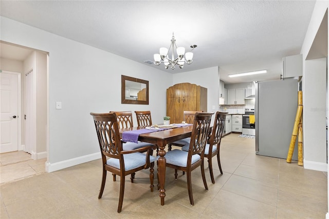 tiled dining space featuring a textured ceiling and a notable chandelier