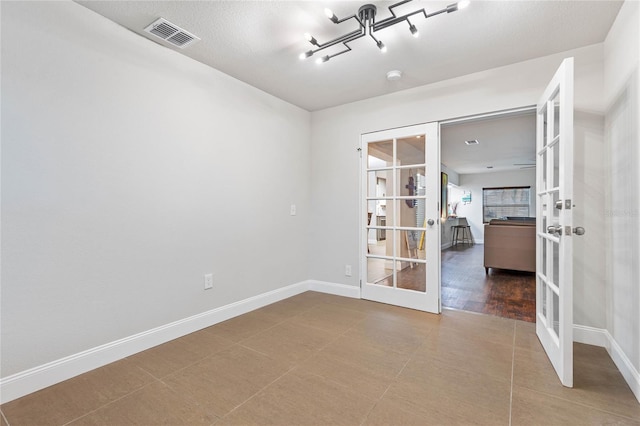 spare room with hardwood / wood-style flooring and french doors