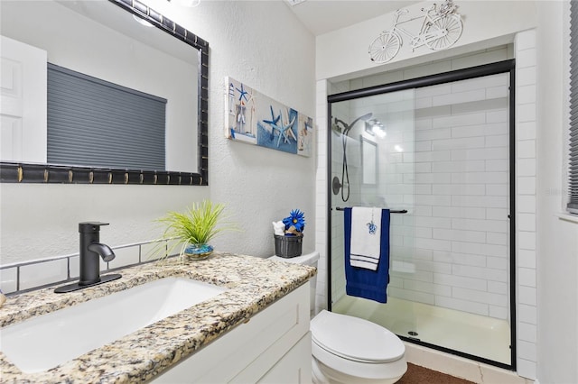 bathroom with vanity, an enclosed shower, and toilet