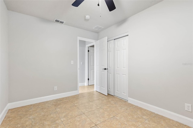 unfurnished bedroom with ceiling fan, light tile patterned floors, and a closet