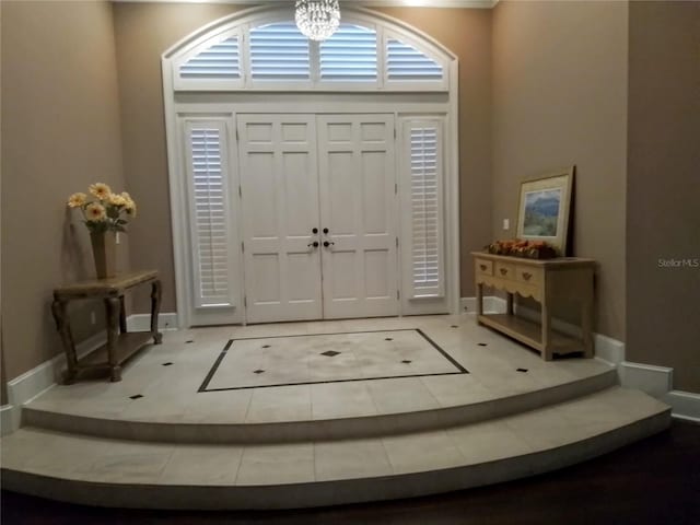 foyer featuring light tile patterned floors and an inviting chandelier