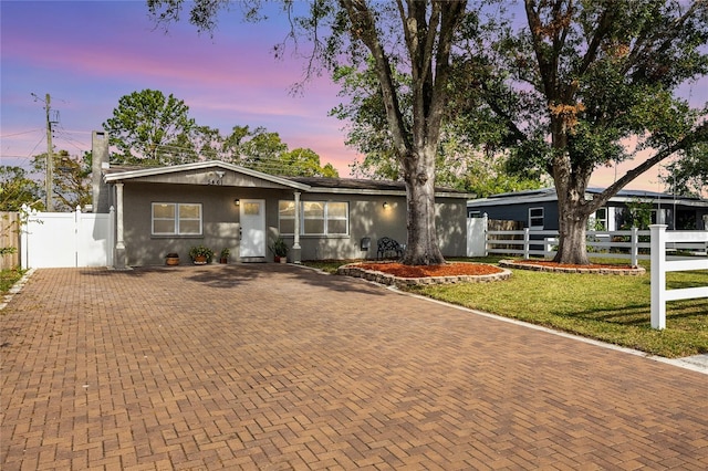 single story home with a lawn