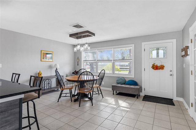 dining area with a notable chandelier and light tile patterned flooring