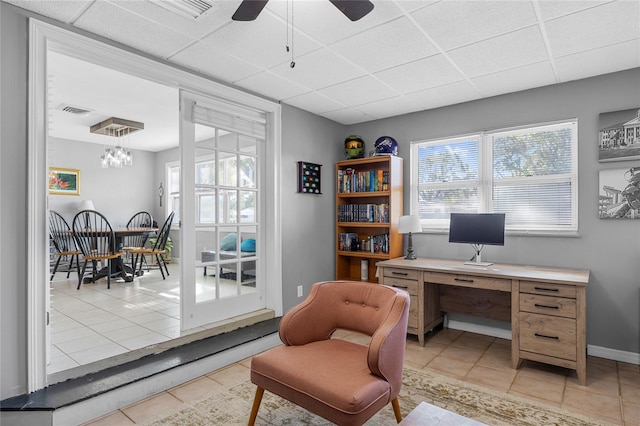 office featuring a paneled ceiling, ceiling fan, and light tile patterned flooring