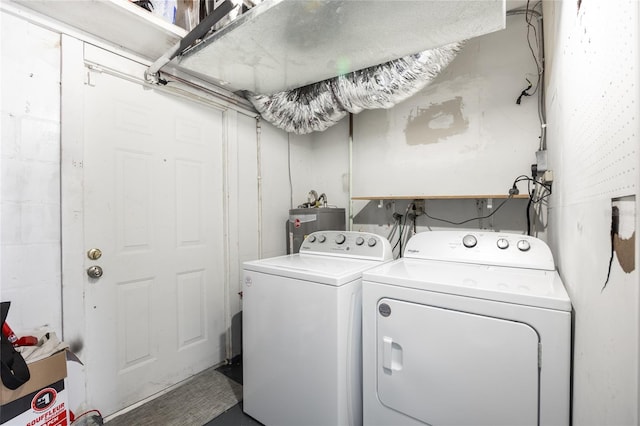 clothes washing area featuring water heater and washer and dryer