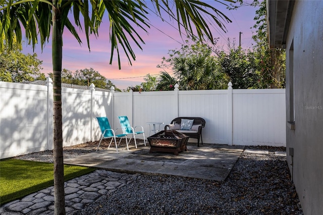 patio terrace at dusk featuring a fire pit